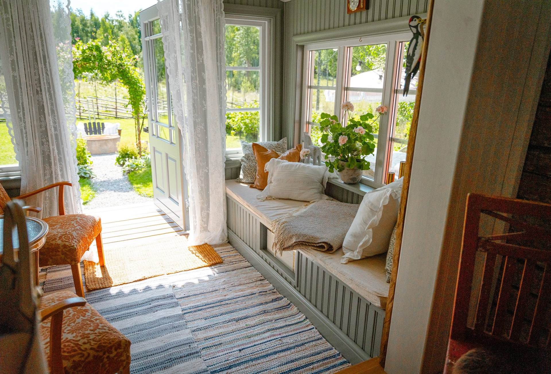 Glazed veranda with a cushioned daybed and the garden door open
