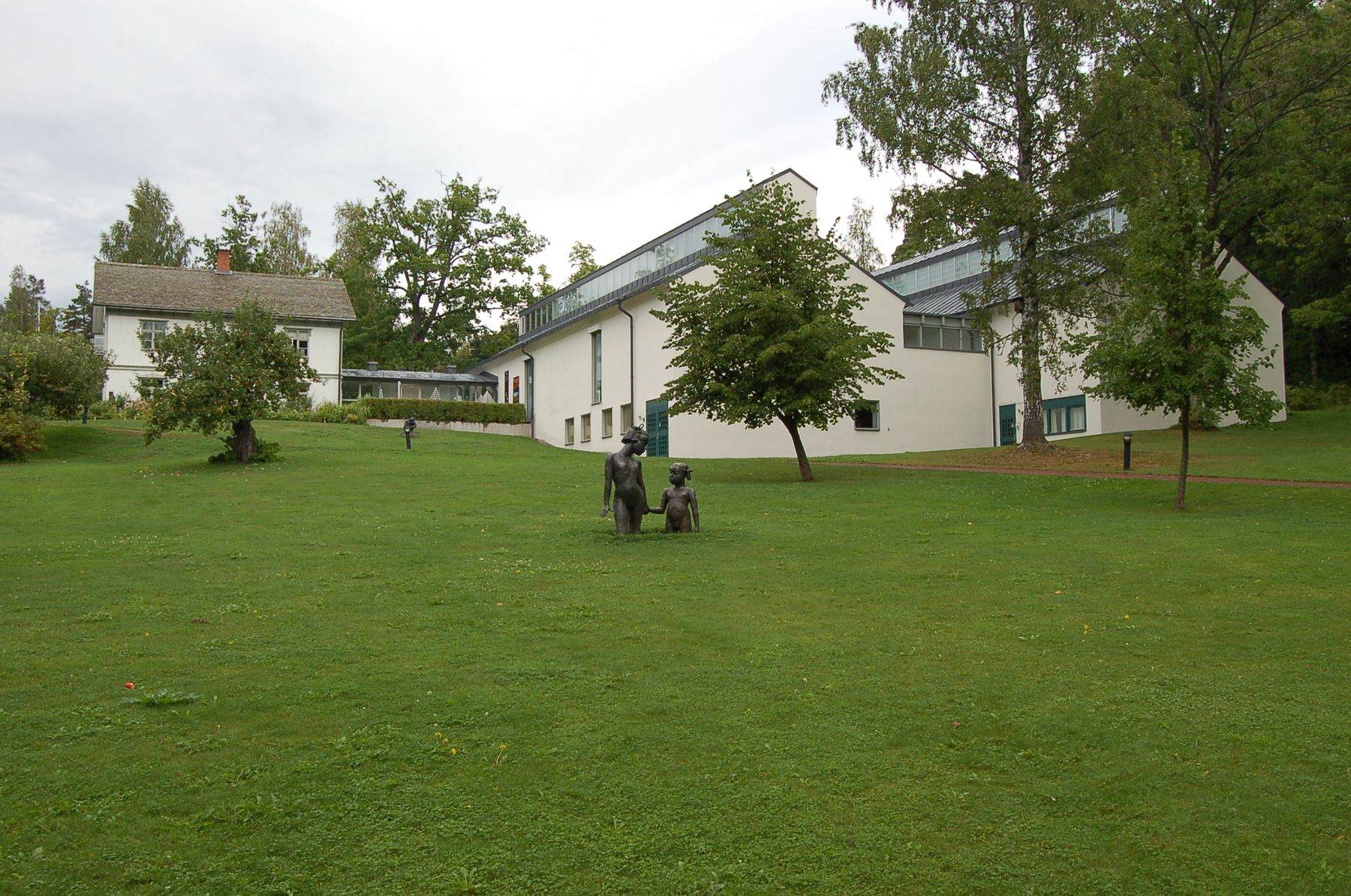 Rackstadmuseet seen across its lawn, with a sculpture in the grass